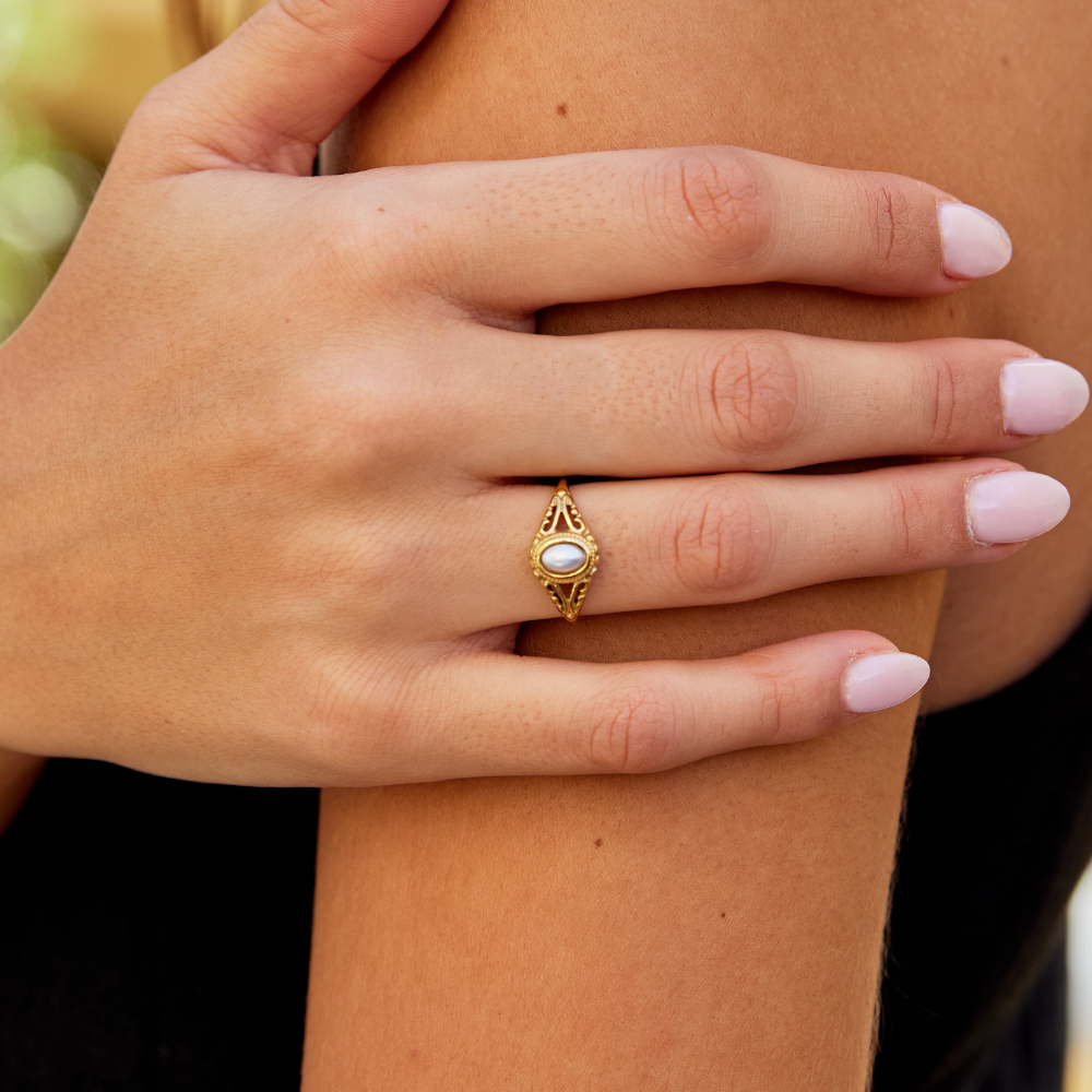 Nora – Gylden statement-ring med buet linje.