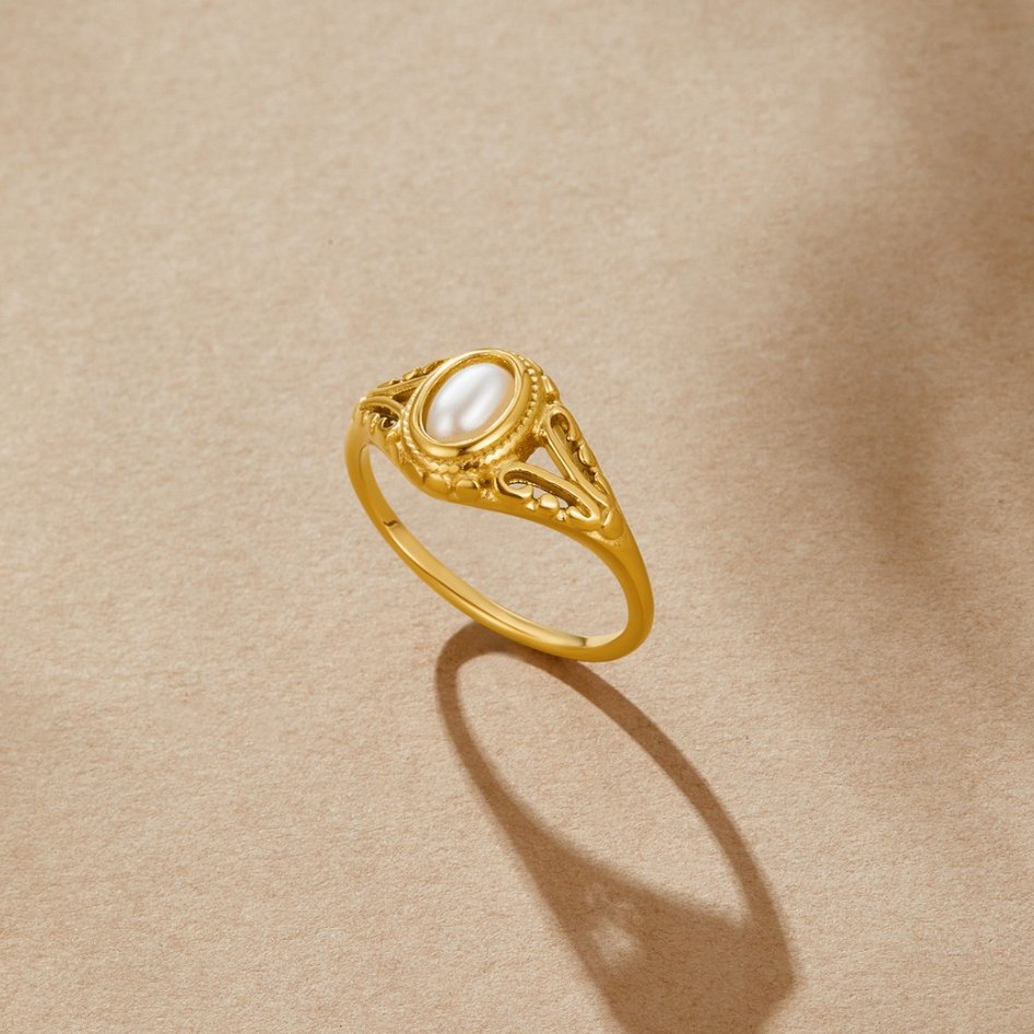 Nora – Gylden statement-ring med buet linje.