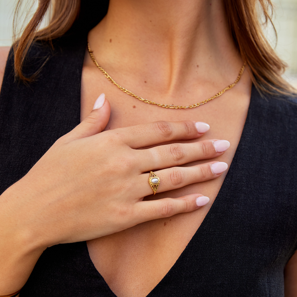 Nora – Gylden statement-ring med buet linje.