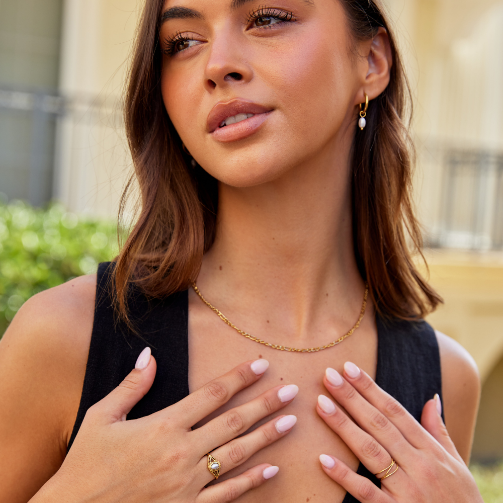 Nora – Gylden statement-ring med buet linje.