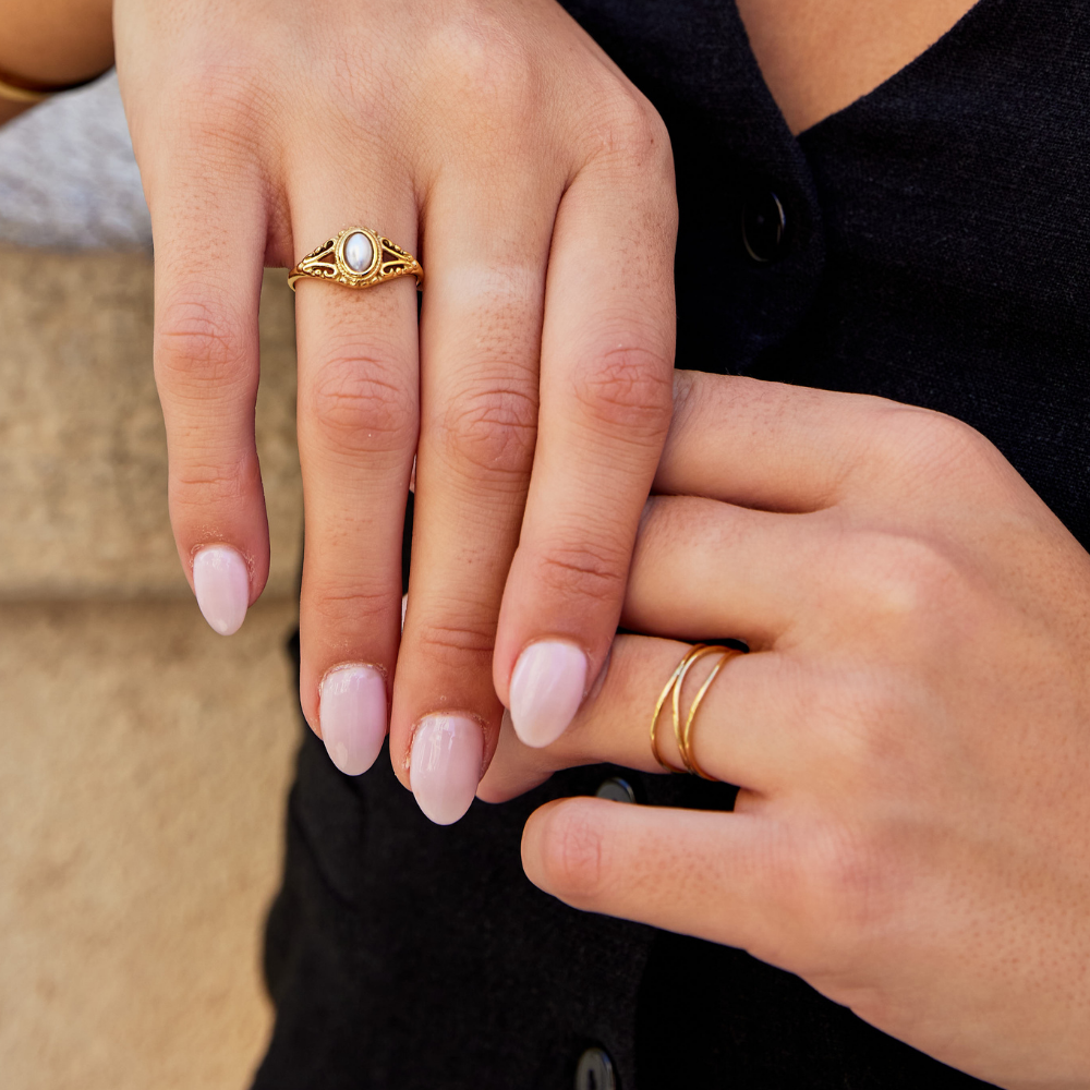 Nora – Gylden statement-ring med buet linje.